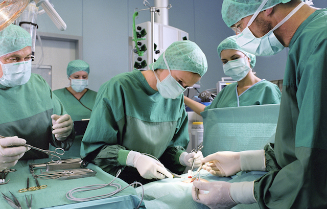Group of surgeons working in operating theatre